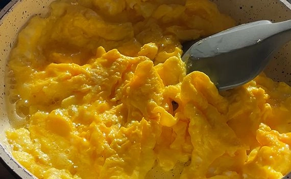 Scrambled eggs in a pan with a spatula stirring them