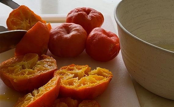 Cutting boiled clementines in half.