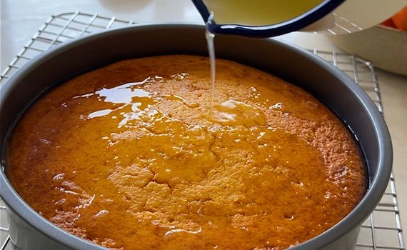 Adding lime sugar syrup to a clementine cake