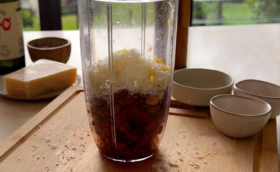 Ingredients for sun-dried tomato pesto in a container