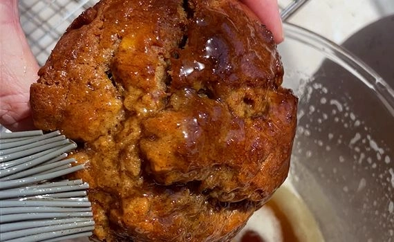 brushing brown butter onto a muffin