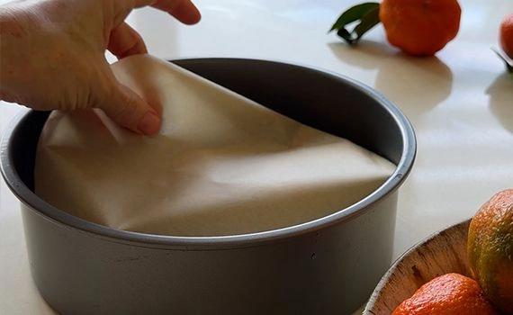 Adding baking paper to a cake tin.