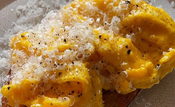Scrambled eggs on toast with parmesan and pepper to make the cacio e pepper flavour