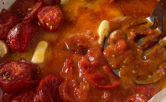 Mashing the roasted tomato and garlic with butter and smoked paprika