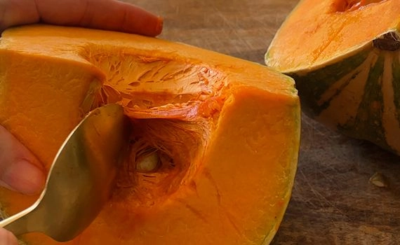 Scooping seeds from a pumpkin