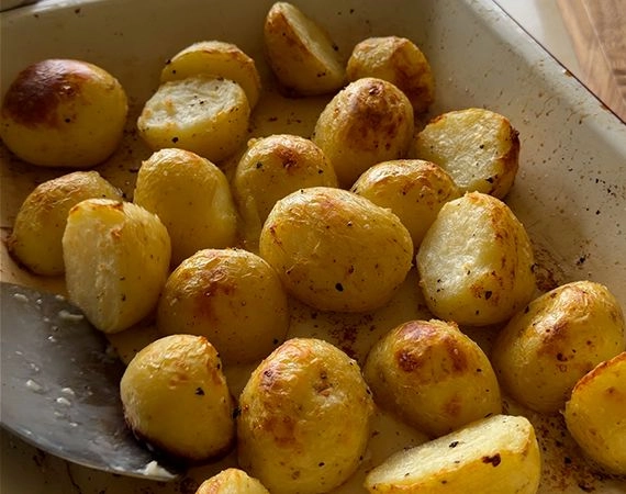 Partially roasted potatoes in a tray