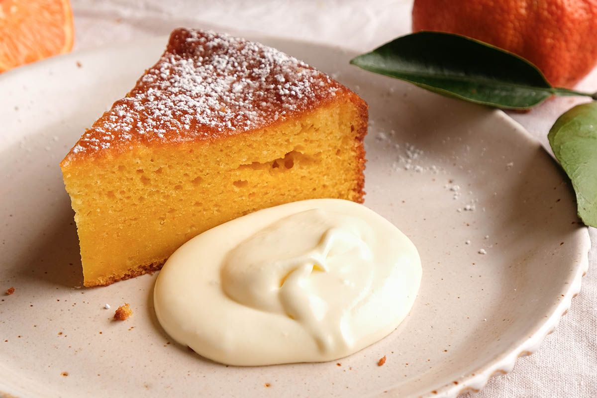 A slice of clementine cake with cheesecake citrus cream.
