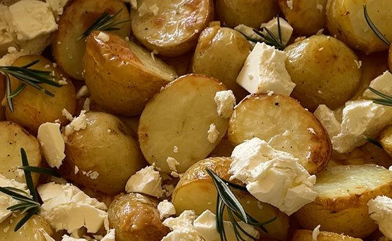Partially roasted potatoes with feta and rosemary lemon and butter added.