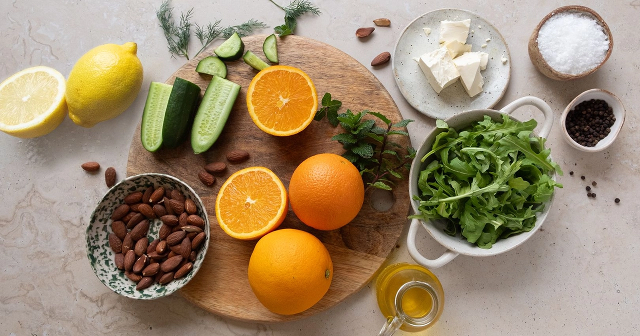 Ingredients to make orange salad with feta, cucumber and herbs