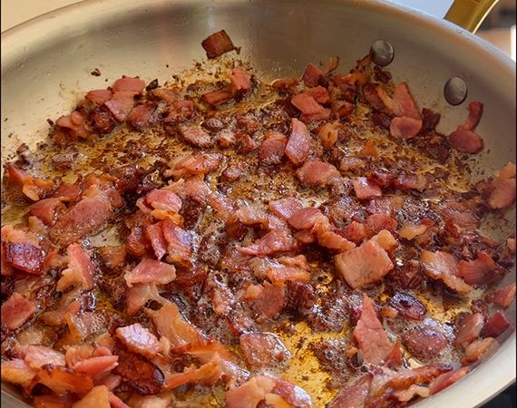 frying bacon in a pan.