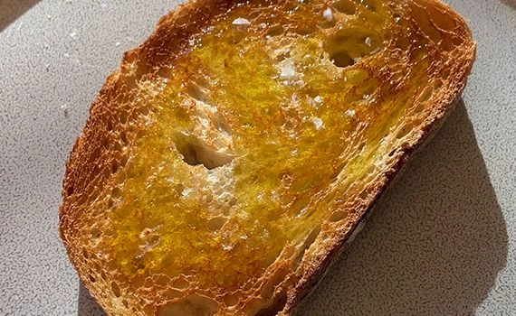 Olive oil and salt being added to toast