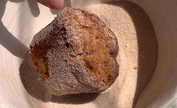 Rolling a muffin in cinnamon sugar