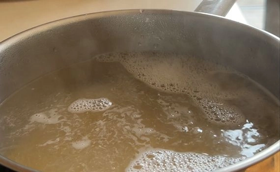 A pot of pasta cooking in boiling water.